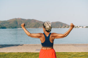 Senior gray-haired woman doing exercises in public park