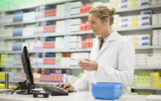 Pharmacist using a computer to look at a prescription in a pharmacy