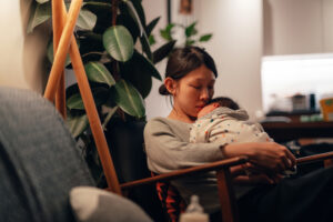 A mother looking dispondent holding her new born baby to her chest