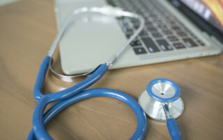 Doctors desk with stethoscope and laptop