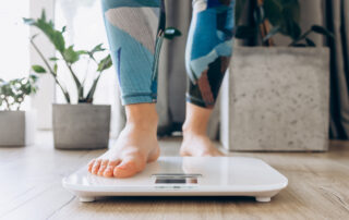 Close-up of bare feet stepping onto a digital scale in a modern home setting