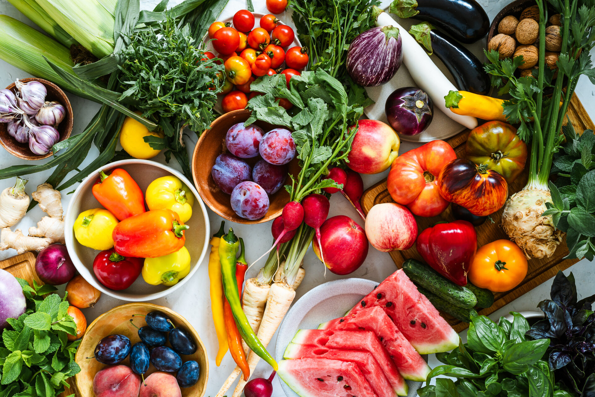 Fresh homegrown vegetables and fruits on kitchen table summer harvest still life table top view Fresh homegrown vegetables and fruits on kitchen table summer harvest from a table top view