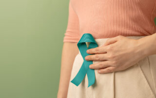 Woman Holding Teal Ribbon on Lower Abdomen demonstrating Cervical Cancer Awareness
