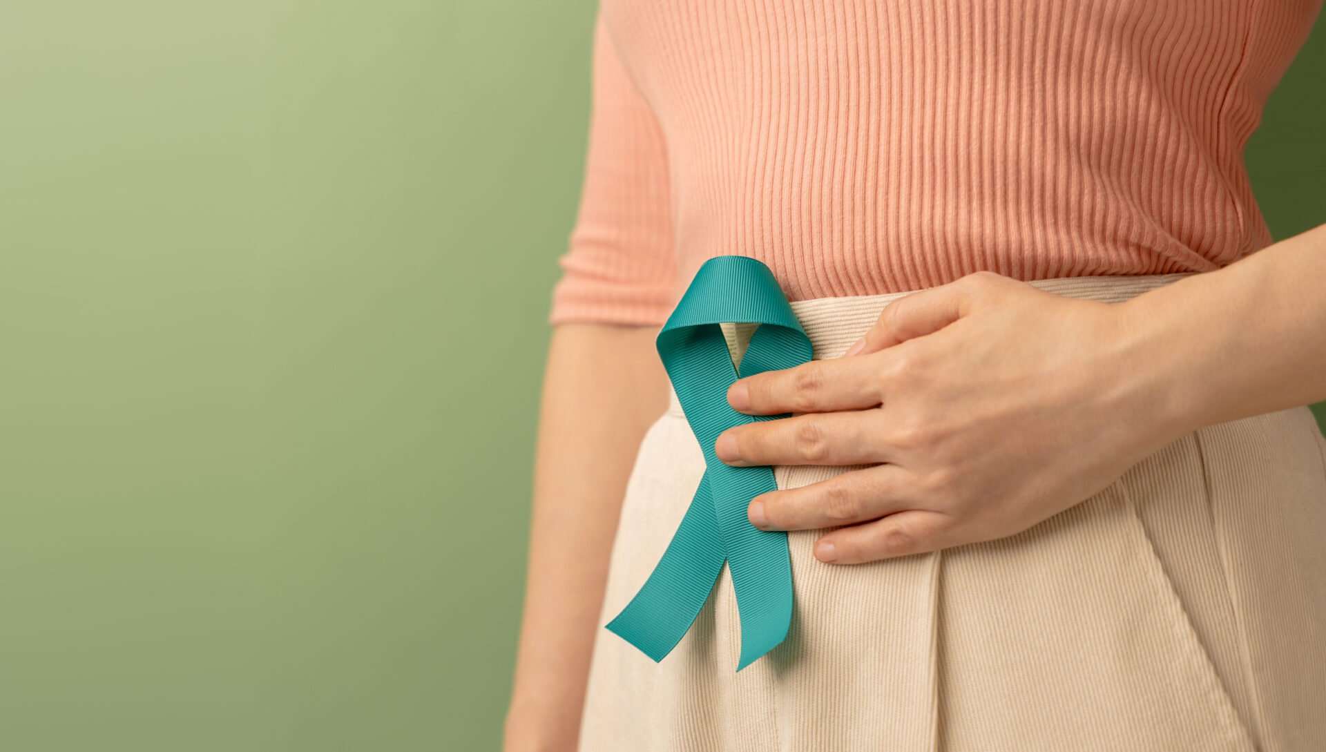 Woman Holding Teal Ribbon on Lower Abdomen demonstrating Cervical Cancer Awareness