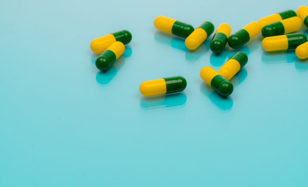 Tramadol pills Green-yellow capsule pills on blue background Tramadol is a strong painkiller medicine used to treat moderate to severe pain Background for tramadol misuse topics Opioids drug Tramadol pills Green-yellow capsule pills on blue background Tramadol is a strong painkiller medicine used to treat moderate to severe pain Background for tramadol misuse topics Opioids drug