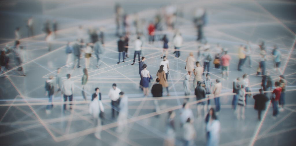 Crowd of people in a futuristic, connected space with glowing network lines overhead, symbolizing global connectivity and datalinks.