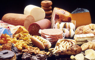 Assorted cheeses (various shapes and colors) with crackers and bread on a cheese platter.