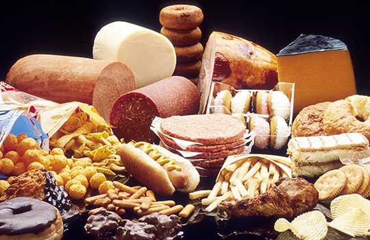 Assorted cheeses (various shapes and colors) with crackers and bread on a cheese platter.
